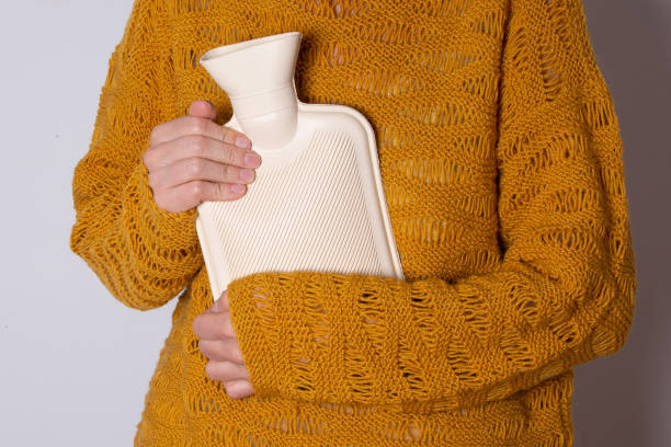 istock Hot water heating pad is winter essentials.  Power outages and difficulties with heating. Saving electricity. Woman in orange sweater holding heating pad. 1469927896