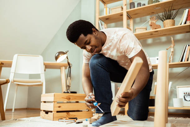 istock African American young man folding a wooden table at home 1469929829
