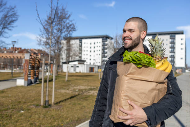 istock Smiling man holding bag with groceries 1469933180