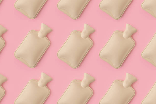 istock Hot water heating pad pattern on pink background. Winter essentials.  Power outages and difficulties with heating. Saving electricity. Cramps problems, heat therapy and cooling down. 1469933752