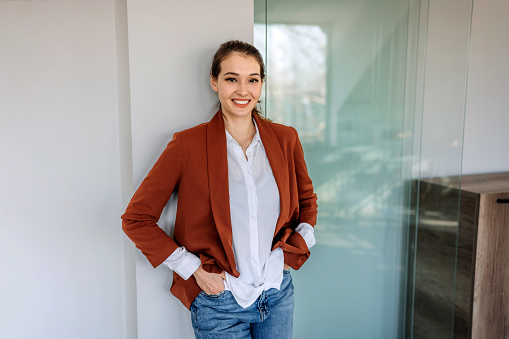 Portrait of young beautiful well dressed woman in a small office