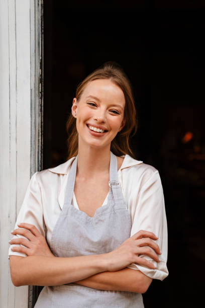 istock Young white waitress woman wearing apron smiling while working in cafe 1469938507