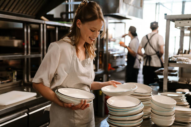 istock Young blonde woman holding plates while working in restaurant kitchen 1469938616