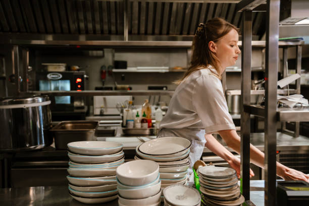istock Young blonde woman holding plates while working in restaurant kitchen 1469938621