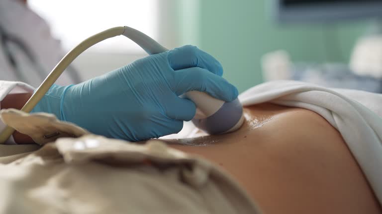 Hands on a woman's stomach, ultrasound abdominal cavity