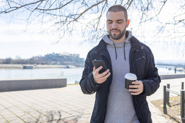 istock Man with coffee to go and smart phone 1469941174
