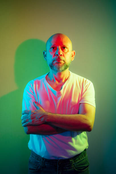istock Male model portrait in studio with colored lights. 1469942106