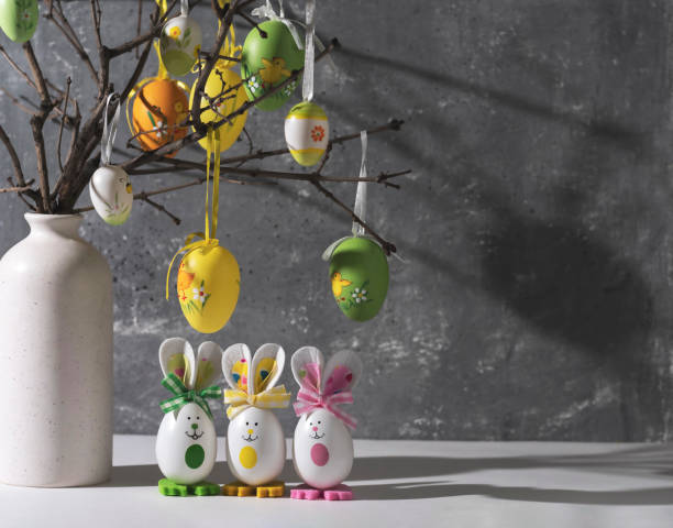 istock Vase with branches decorated with Easter eggs. Funny bunnies made of eggshells.Easter decoration, space for a text. 1469942313