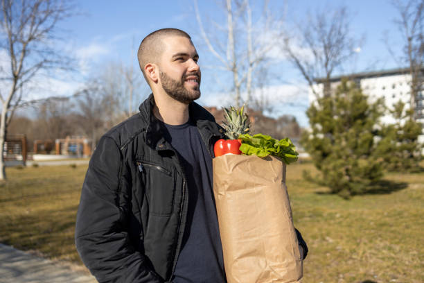 istock Smiling man with bag full of groceries 1469943513