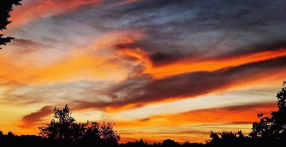 Mix of colors like red, purple and orange stripes, in the sky at dusk