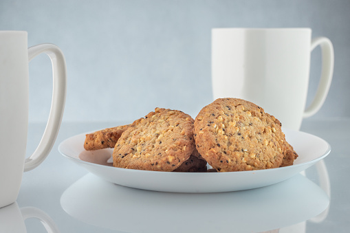 Coffee and cookies. Time to relax. White cups with coffee and roasted seeds.