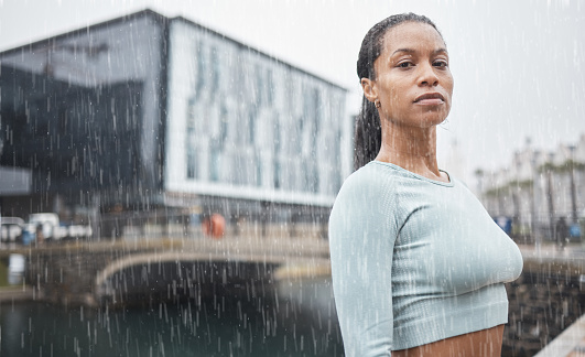 istock Fitness, motivation and black woman in rain in city for workout, marathon training and running. Sports, winter and portrait of female athlete exercise for healthy lifestyle, wellness and inspiration 1469944892