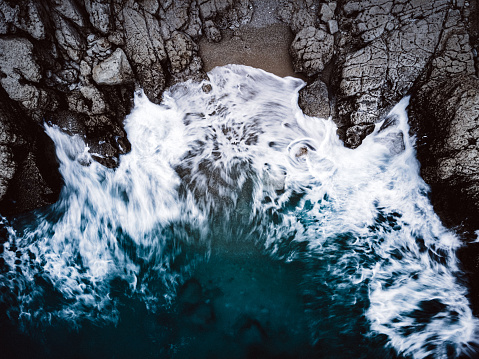 Dramatic waves breaking stones. Shoot directly above with long exposure