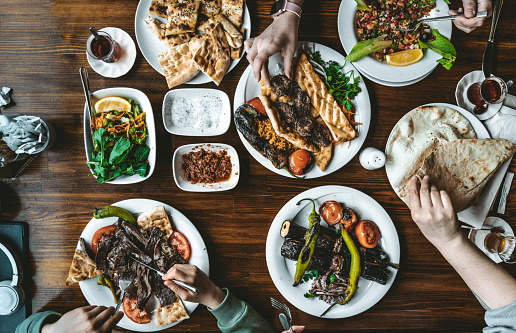 Top view of traditional Turkish grilled food with snacks and vegetables on table. People taking various food
