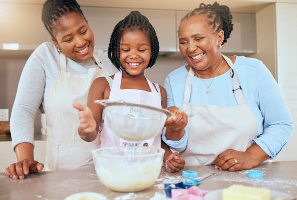 istock Happy family, child and cooking in kitchen together for bonding or learning development activity. Black family, grandmother and mother teaching kid baking skills for independence in retiement home 1469947088
