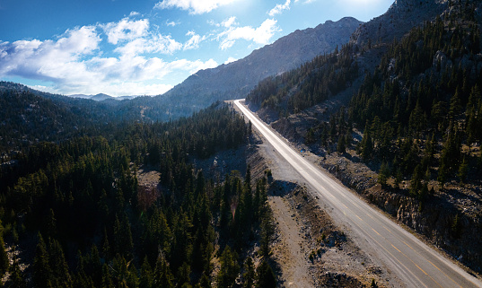 Beautiful road in mountains at sunset and dramatic lights. Aerial shot