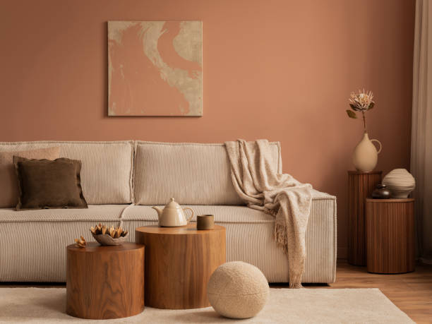 istock Creative composition of cozy living room interior with mock up poster frame, modular sofa, wooden coffee table, rug, pillow, vase with dried flower stand and personal accessories. Home decor. Template 1469948579