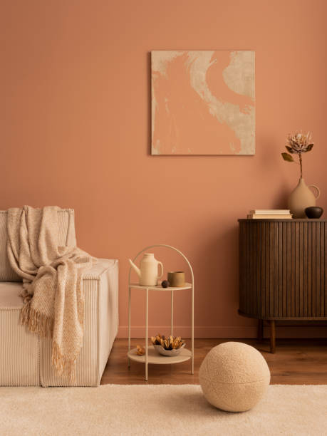 istock Creative composition of living room interior with mock up poster frame, wooden sideboard, modular beige sofa, beige coffee table, rug, pink wall and personal accessories. Home decor. Template. 1469948725
