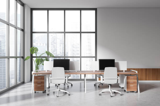 istock Light office interior with pc computer and armchairs near window. Mockup wall 1469950189