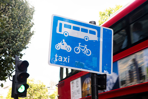 Road sign and red London bus in the City of Westminster