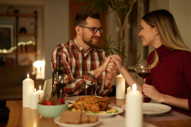 istock Beautiful couple having romantic dinner with candles and red wine at home 1469951992