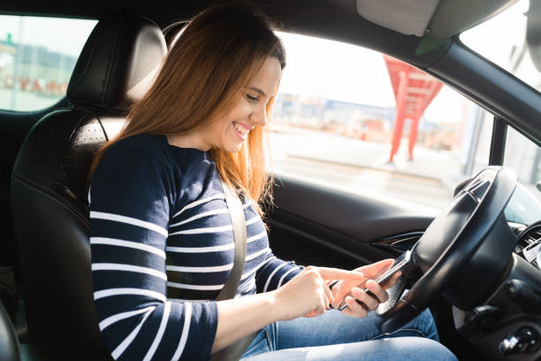 istock Young woman using smartphone in her car 1469952123