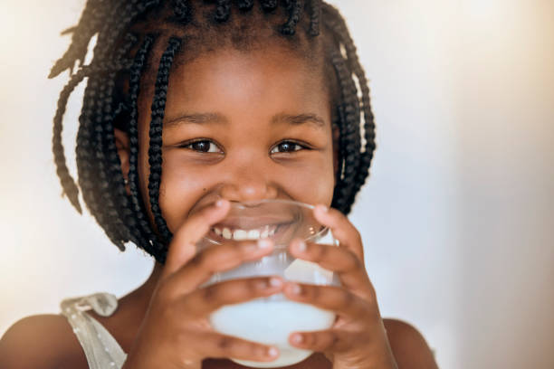 retrato de leche, salud y nutrición del niño negro para el bienestar, el calcio y la dieta con sonrisa. joven, niña y niño feliz sosteniendo una bebida láctea en vaso para un estilo de vida saludable con maqueta. - beauty beautiful braids dairy product fotografías e imágenes de stock