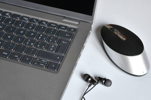 istock Workplace with modern laptop, earphones and computer mouse on white desk. 1469956773