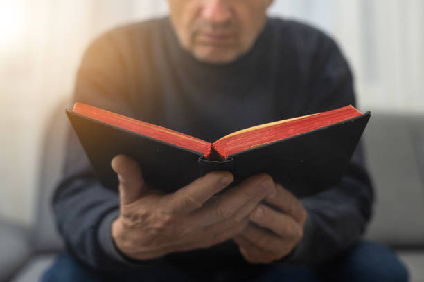 istock Man praying and reading Bible at home. 1469956911