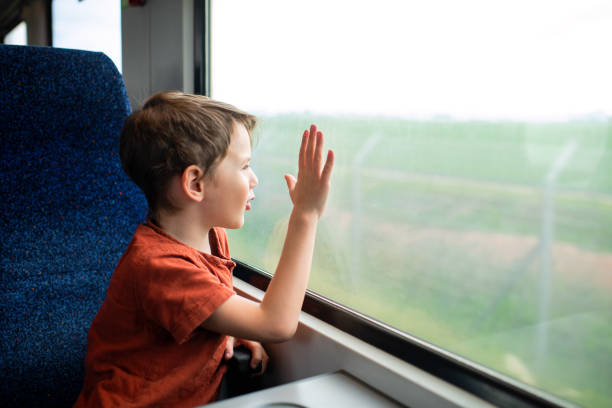 istock Happy boy traveling by train on summer vacations and looking through the window 1469957258