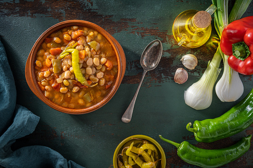 Pochas a la Navarra Spain white beans traditional stew with peppers and chili on a clay plate, Mediterranean food vegan plant based.