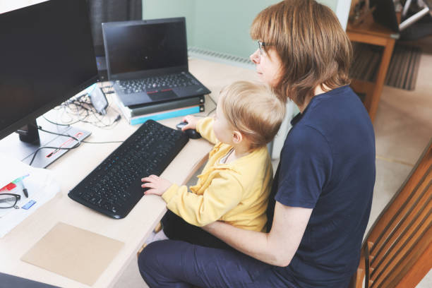 istock Cute 2 year old girl learning at a home computer with her grandmother 1469958909