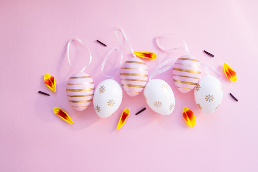 Easter eggs hand painted in a straw basket isolated on white background
