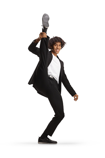 African american man in a suit dancing and lifting leg up isolated on white background