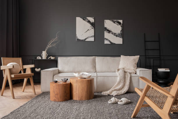 istock Elegant composition of living room interior with mock up poster frame, beige modular sofa, wooden coffee table, slippers, rattan armchair, braided plaid and personal accessories. Home decor. Template. 1469963630