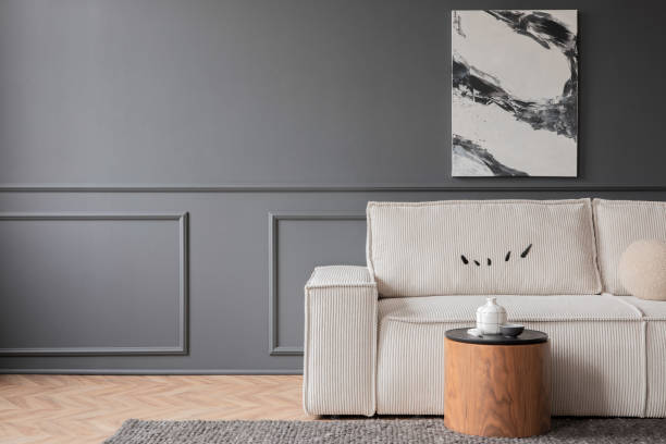 istock Minimalist composition of living room interior with mock up poster frame,  copy space, modular sofa, wooden coffee table, carpet, dark wall with stucco and personal accessories. Home decor. Template. 1469963643