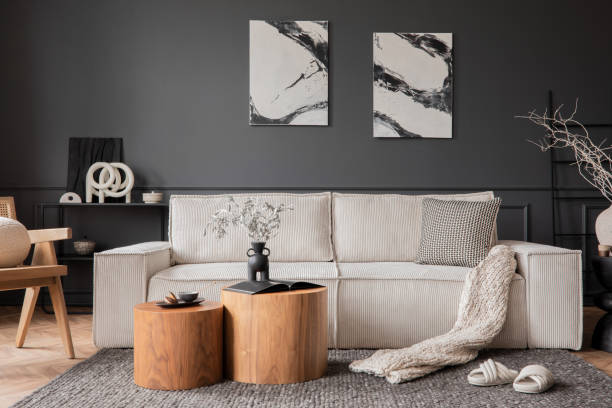 istock Elegant composition of living room interior with mock up poster frame, beige modular sofa, wooden coffee table, slippers, rattan armchair, braided plaid and personal accessories. Home decor. Template. 1469963931
