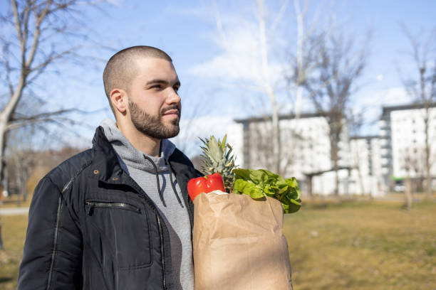 istock Smiling man holding bag with groceries 1469965586