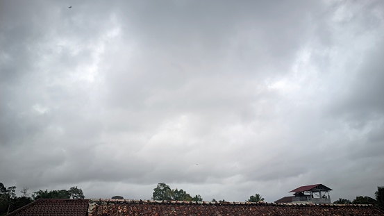 cloudy weather mood in a residential area in southeast Asia , cloudy sky , residential roofs , rainy season