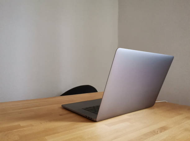 istock Silver laptop on a light wooden desk 1469968303