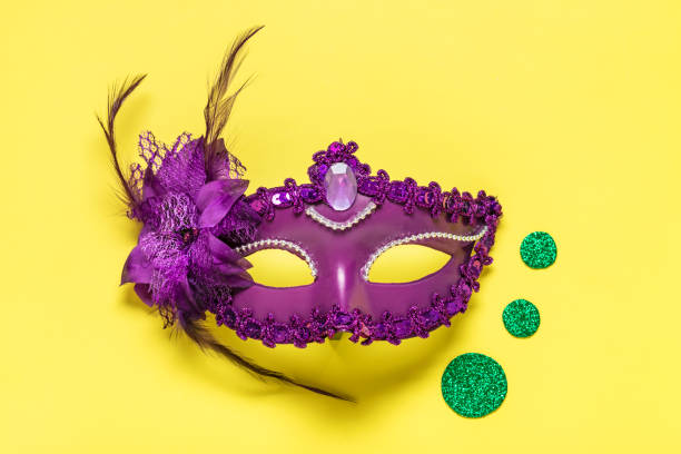 istock Mardi gras concept. Congratulation card with violet mask on yellow background Top view 2023 Mardi Gras Parade Schedule Mockup Copy space 1469970256