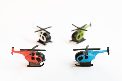 A closeup of four colorful helicopter miniatures isolated on white surface
