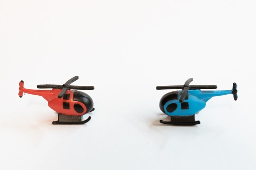 A closeup of two colorful helicopter miniatures isolated on white surface