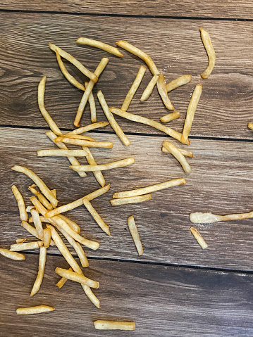 Stock photo showing a portion of fast food French fries have been spilt across the floor, wasting food that would otherwise be been eaten, elevated view of ruined takeaway food.