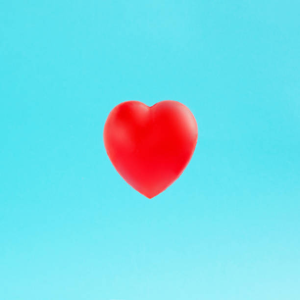 istock Valentines' day background with red heart floating isolated on pastel blue background. Love card for birthday, anniversary. Love is in the air. Romantic moment. 1469970859