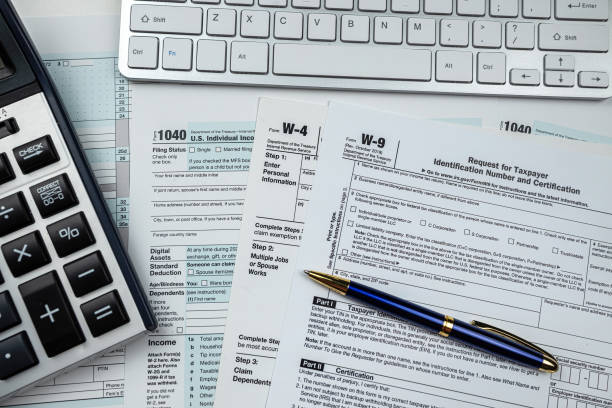 formulaire fiscal américain 1040 vierge 2022 avec calculatrice et clavier sur le bureau - formulaire des impôts photos et images de collection