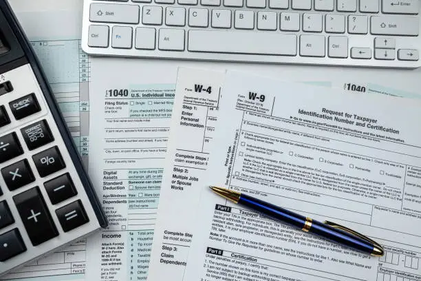 2022 blank 1040 us tax form with calculator and keyboard on office desk. Financial accounting concept