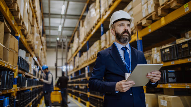 istock Manager in suit controlling goods in a waehouse. 1469972432