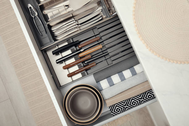 istock Open drawer of kitchen cabinet with different utensils, dishware and towels, top view 1469972912