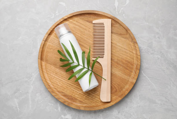 istock Dry shampoo spray, green twig and comb on light grey marble table, top view 1469972940